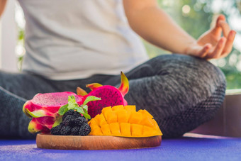 手女人冥想瑜伽构成坐着莲花水果前面龙水果芒果桑