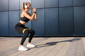 运动女人<strong>下蹲</strong>健身口香糖扩张器在户外