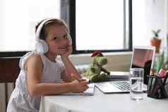 距离学习快乐的女孩女孩耳机移动PC研究在线电子学习系统