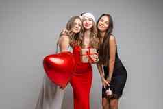 漂亮的年轻的女孩朋友节日礼服持有礼物红色的气球香槟庆祝假期灰色的背景