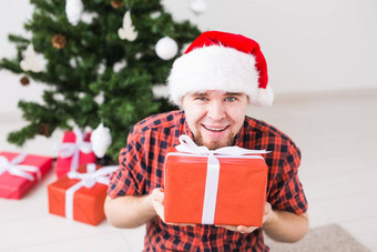 圣诞节假期概念有趣的男人。圣诞老人他持有礼物首页生活房间