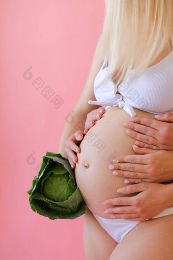 金发女郎怀孕了女人内衣持有肚子保持卷心菜