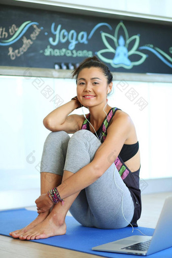 肖像微笑瑜伽女人坐着瑜伽席锻炼瑜伽工作室瑜伽女人