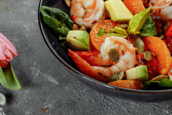 虾沙拉樱桃西红柿黄瓜鳄梨生菜石榴菜健康的海鲜概念美味的烤虾虾混合蔬菜沙拉黑色的前视图