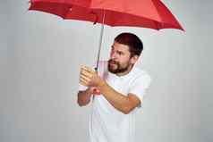 有胡子的男人。保护雨红色的伞光背景