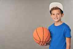 快乐的男孩篮球球员持有橙色游戏球