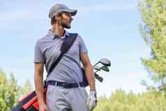 高尔夫球球员走携带袋夏天游戏打高尔夫球