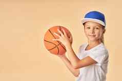 可爱的快乐的女孩帽持有篮球球