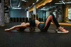 完整的放松锻炼完整的长度年轻的运动型女人运动服装锻炼泡沫辊说谎瑜伽席健身房伸展运动练习