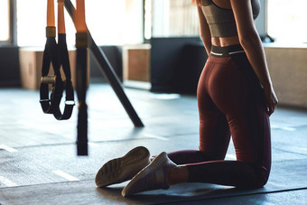 裁剪拍摄运动女人运动服装锻炼地板上健身房跪着
