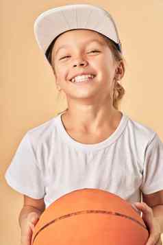 快乐的女孩子帽持有篮球球