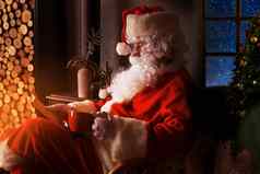 肖像快乐圣诞老人老人坐着房间首页壁炉阅读圣诞节信列表