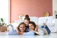 年轻的高加索人家庭小女儿构成放松地板上生活房间微笑女孩孩子拥抱拥抱父母显示爱感激之情休息首页