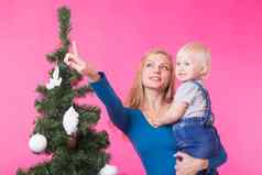 圣诞节假期人概念年轻的快乐女人女儿手显示装饰圣诞节树