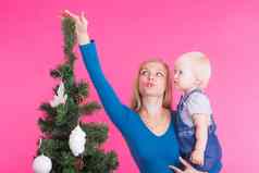 圣诞节假期人概念年轻的快乐女人女儿手显示装饰圣诞节树
