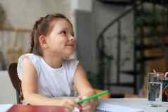 女孩坐桌子上写作笔记本练习首页孩子手写准备家庭作业