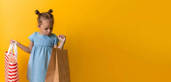 横幅肖像高加索人美丽的快<strong>乐学</strong>前教育女孩微笑快乐的持有纸板袋孤立的橙色黄色的背景幸福消费主义出售人购物概念