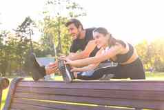 快乐年轻的夫妇锻炼公园伸展运动练习