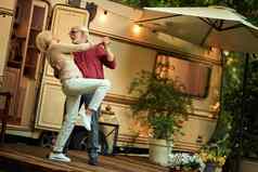 快乐的结婚了夫妇享受跳舞在户外房车
