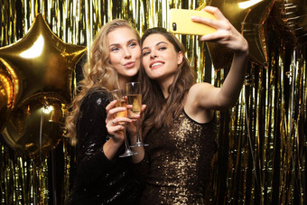 图像有吸引力的女孩时尚的装持有智能手机采取自拍照片黄金背景