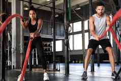 运动年轻的夫妇战斗绳子锻炼功能培训健身健身房