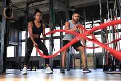 运动年轻的夫妇战斗绳子锻炼功能培训健身健身房
