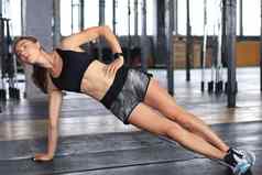 肌肉发达的体育运动女人一边板材健身房