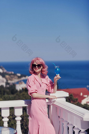 肖像美丽的女人享受色彩斑斓的鸡尾酒全景视图酒店阳台夏天一天