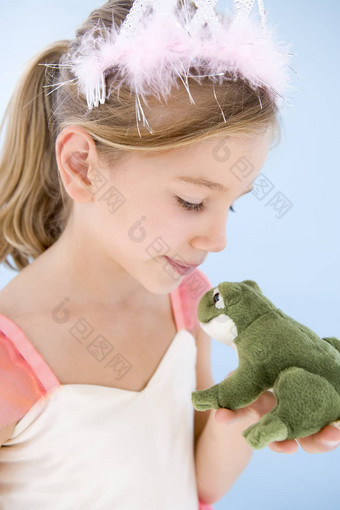 年轻的女孩公主服装接吻豪华的青蛙