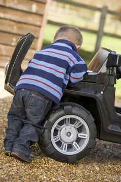 年轻的男孩玩在户外玩具卡车