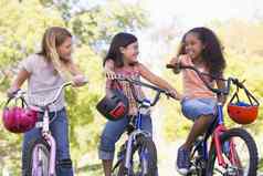 年轻的女孩朋友在户外自行车微笑