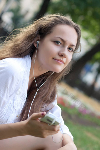 年轻的女人听音乐一对耳机