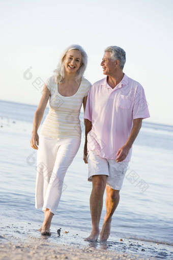 夫妇海滩持有手微笑