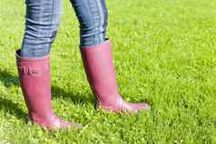 细节女人穿橡胶靴子草坪上