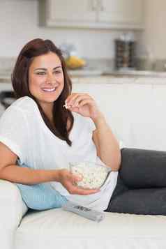 女人吃爆米花放松沙发