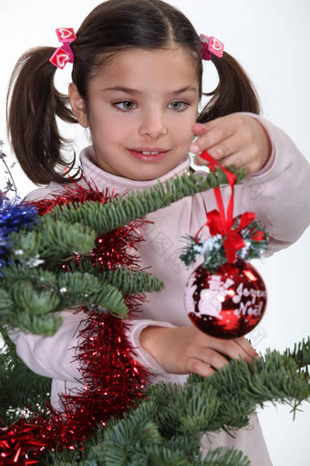 年轻的女孩装修圣诞节树