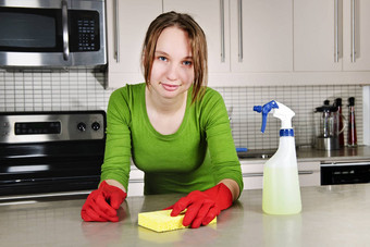 年轻的女人清洁厨房