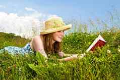 年轻的女孩阅读书草地
