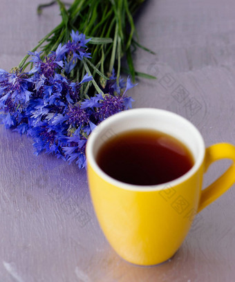 黄色的杯茶花束矢车菊