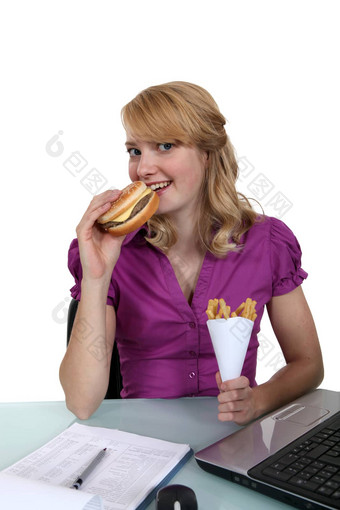女人吃芝士汉堡薯条桌子上