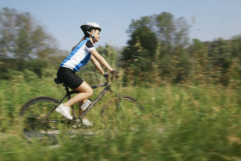 年轻的女人培训山自行车骑自行车公园