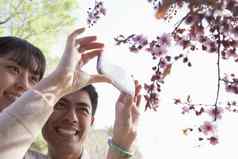 微笑夫妇采取照片分支樱桃花朵公园春天