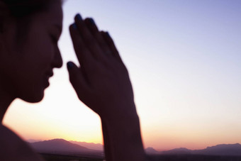 宁静年轻的女人眼睛关闭手祈祷构成沙漠中国焦点背景