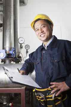 肖像微笑工人剪贴板检查石油管道设备气体植物北京中国