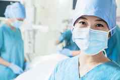 肖像女外科医生穿外科手术面具操作房间特写镜头