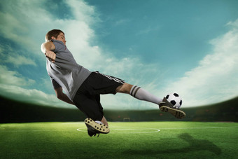 足球球员踢足球球中期空气体育场天空