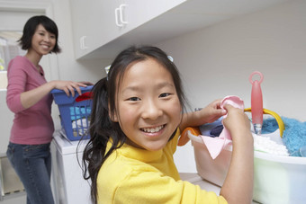 肖像十几岁的女孩洗衣房间妈妈。背景