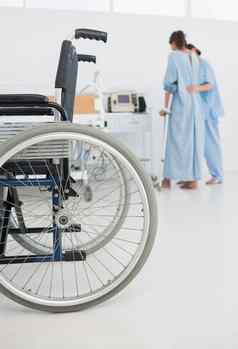 医生帮助病人走轮椅前景