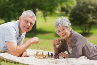 快乐高级夫妇玩国际象棋公园