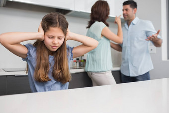 伤心女孩覆盖耳朵父母争吵厨房